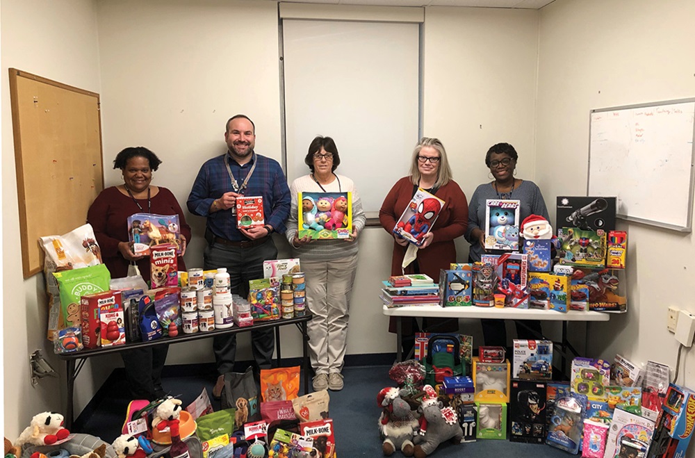Staff from the Nursing Network Center stand with pet supplies and children’s toys 